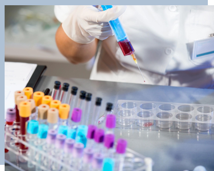 A person holding a test tube in front of many other tubes.